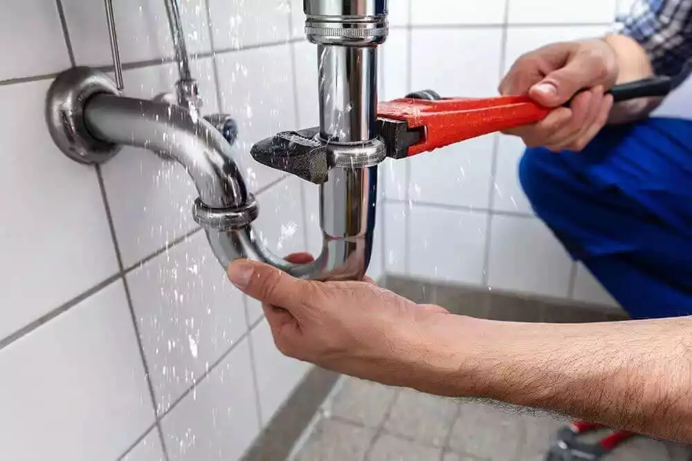 Emergency plumber repairing burst pipe