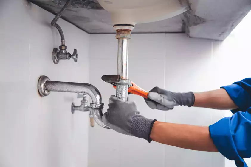 Professional plumber repairing pipes in Miami home